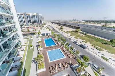 an overhead view of a building with a swimming pool at Studio Near Meydan Golf Club, 15-Minute Drive to Dubai Mall, Burj Khalifa and Downtown Attractions, Azizi Riviera 46, Al Merkadh by Deluxe Holiday Homes in Dubai