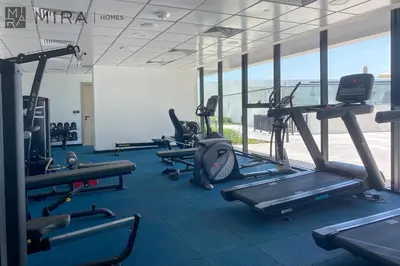 a gym with several treadmills and elliptical machines at Mira Holiday Homes - Luxury, Stylish & Cozy Studio in Downtown Jebel Ali in Dubai