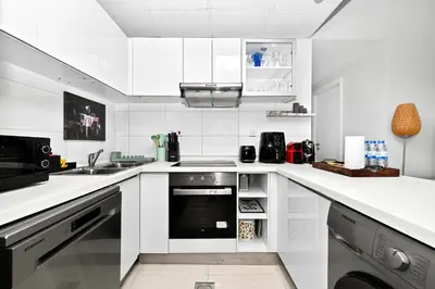 a white kitchen with a sink and a dishwasher at Fantastic 2 Bed - Marina in Dubai