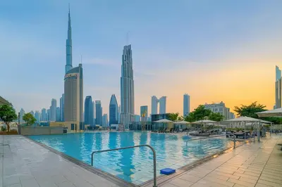a swimming pool with a city skyline in the background at Infinity Pool Walk to Burj Khalifa Downtown 1BR in Dubai