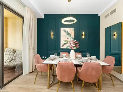 a dining room with green walls and a table with pink chairs at Breathtaking Sea View and Dubai Eye 2BR in Dubai