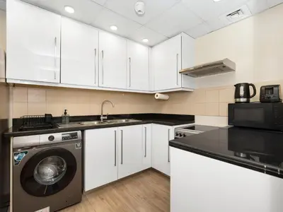 a kitchen with white cabinets and a washing machine at Breathtaking Sea View and Dubai Eye 2BR in Dubai