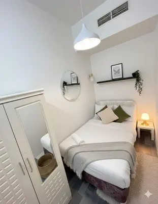 a small bedroom with a bed and a mirror at Peace Corner Partition Room In Barsha Heights Tecom in Dubai