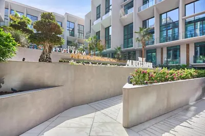 a building with a retaining wall with flowers and plants at Modern Studio Elegant & Comfort in Dubai