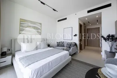 a white bedroom with a bed and a bathroom at Bloomfields Cozy Stu Binghatti Azure in Dubai