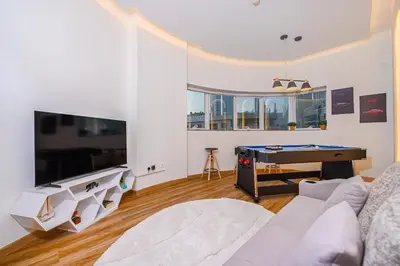 a living room with a couch and a pool table at Luxurious 3BR with a pool table at Marina Walk in Dubai