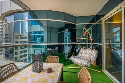 a balcony with a swing and a table and chairs at Luxurious 3BR with a pool table at Marina Walk in Dubai