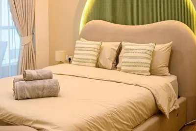 a bedroom with a large bed with a green headboard at Luxurious 3BR with a pool table at Marina Walk in Dubai