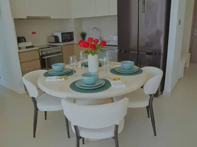 a kitchen with a table with plates and red flowers on it at Stylish-2BR, Burj Royale, 3 min walk to Dubai Mall in Dubai