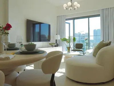 a white living room with a table and a chair at Stylish-2BR, Burj Royale, 3 min walk to Dubai Mall in Dubai