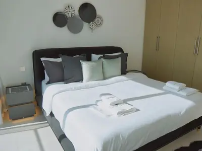 a large white bed with two towels on it at Stylish-2BR, Burj Royale, 3 min walk to Dubai Mall in Dubai