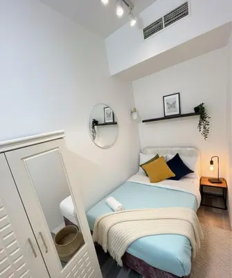a small bedroom with a bed and a mirror at Calm Stay Partition Room In Tecom Barsha Heights in Dubai