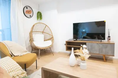 a living room with a tv and two chairs at Boho Style 2BHK Apartment With Sea View Next to Tram Station in Dubai