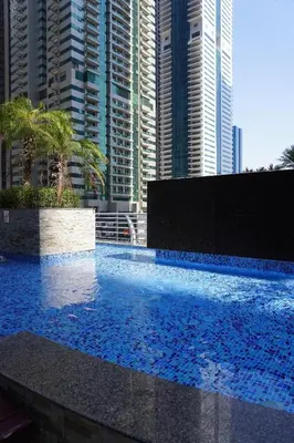 a large swimming pool in a city with tall buildings at Boho Style 2BHK Apartment With Sea View Next to Tram Station in Dubai
