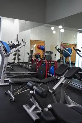 a gym with lots of exercise equipment and a mirror at Boho Style 2BHK Apartment With Sea View Next to Tram Station in Dubai