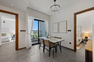a dining room with a table and chairs and a living room at Modern Apartment with Balcony and Pool Access in Dubai