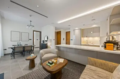 a living room with a couch and a kitchen at Modern Apartment with Balcony and Pool Access in Dubai
