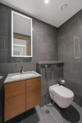 a bathroom with a toilet and a sink and a mirror at Modern Apartment with Balcony and Pool Access in Dubai