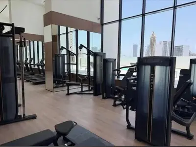a gym with treadmills and exercise equipment in a building at High Rise Studio Pool Gym Binghatti Gardenia JVC in Dubai
