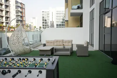 a balcony with a couch and a hammock on a building at RIVIERA HOME ESCAPE 2BHK pool Gym in Dubai