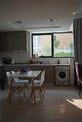 a kitchen with a table and chairs and a sink at RIVIERA HOME ESCAPE 2BHK pool Gym in Dubai