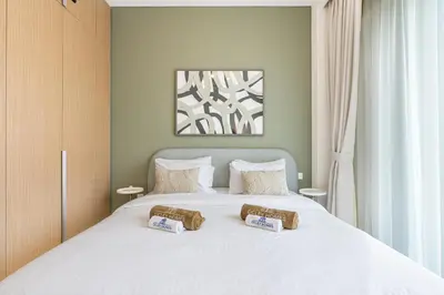 a bedroom with a white bed with two pillows on it at Premium Creek Home Steps from the Lagoon in Dubai