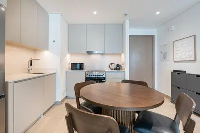 a kitchen with a table and chairs in a room at Premium Creek Home Steps from the Lagoon in Dubai