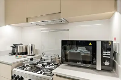 a kitchen with a stove and a microwave at FIRST CLASS 1BR Creek Beach , Relaxing Vibes in Dubai