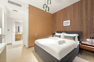 a bedroom with a large bed and a bathroom at FIRST CLASS 1BR Creek Beach , Relaxing Vibes in Dubai