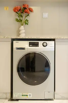 a washing machine in a kitchen with a vase of flowers at Business Bay 1BR Burj Khalifa&Canal Views,3Balcony in Dubai