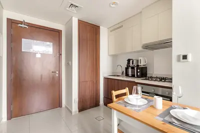 a kitchen with a table and a wooden door at FIRST CLASS 1BR Canal View Escape in Dubai