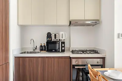 a kitchen with a sink and a microwave at FIRST CLASS 1BR Canal View Escape in Dubai