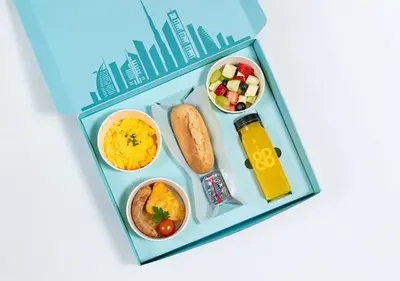 a bento box filled with food and drinks at Cosmos Living Delightful Studio in Dubai
