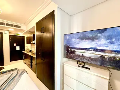 a large flat screen tv on a wall in a bathroom at Cosmos Living Delightful Studio in Dubai