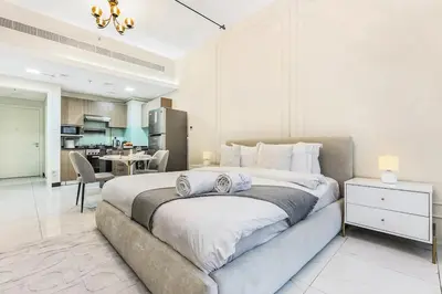 a large bedroom with a large bed and a kitchen at FIRST CLASS Studio Stylish & Cozy JVC Escape in Dubai