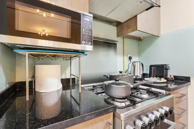 a kitchen with a stove and some pots and pans at FIRST CLASS Studio Stylish & Cozy JVC Escape in Dubai