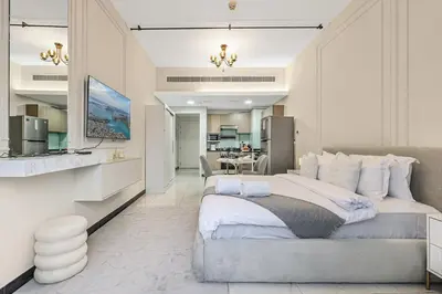 a bedroom with a large bed and a kitchen at FIRST CLASS Studio Stylish & Cozy JVC Escape in Dubai