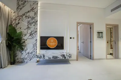 a living room with a tv on a wall at EasyGo - Modern 1BR with Balcony & Amenities in Arjan in Dubai