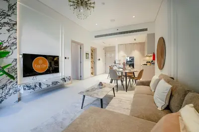 a living room with a couch and a tv at EasyGo - Modern 1BR with Balcony & Amenities in Arjan in Dubai
