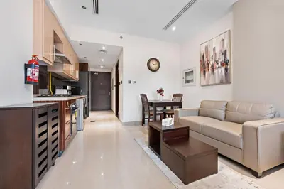 a living room and kitchen with a couch and a table at Chic Studio Near Burj Khalifa in Dubai