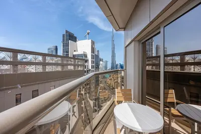 a balcony with two tables and a view of the city at Chic Studio Near Burj Khalifa in Dubai