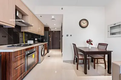 a kitchen with a table and a dining room at Chic Studio Near Burj Khalifa in Dubai