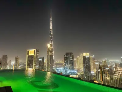 a view of a city skyline at night at Paramount Midtown, Luxury 1BR with Infinity Pool with Burj View in Dubai