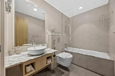 a bathroom with a sink and a toilet and a tub at Paramount Midtown, Luxury 1BR with Infinity Pool with Burj View in Dubai