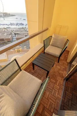 two chairs and a bench on a balcony with the beach at Full Sea View Luxury Large 1 BR in JBR in Dubai