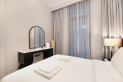 a hotel room with a bed and a mirror at Two Identical Apartments - Same Building in Dubai