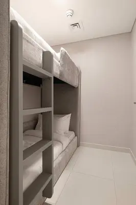 a room with a bunk bed with white pillows at Two Identical Apartments - Same Building in Dubai