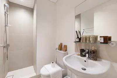 a bathroom with a toilet and a sink and a shower at Two Identical Apartments - Same Building in Dubai