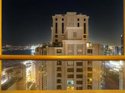 a view of a building from a window at night at Beachfront 2BR Dubai Eye & Sea View Beach Access in Dubai