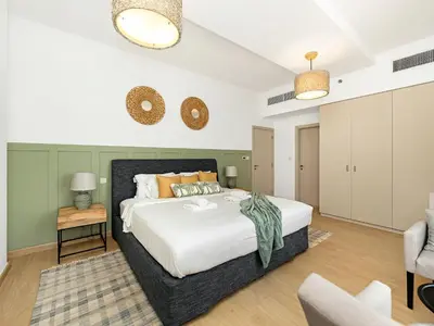 a bedroom with a large bed and a chair at Beachfront 2BR Dubai Eye & Sea View Beach Access in Dubai
